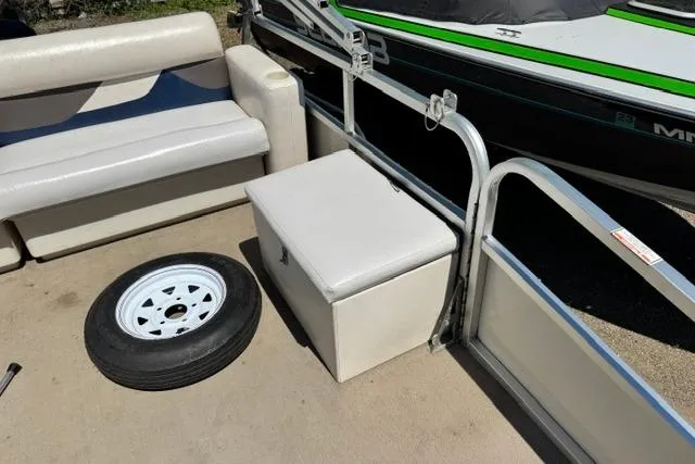Slide: The Image of 2005 Misty Harbor 1680FS boat interior with seating, storage box, and spare tire. - 17