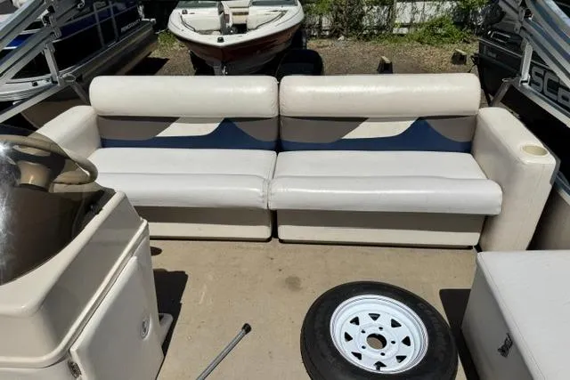 Slide: The Image of 2005 Misty Harbor 1680FS boat interior with beige seating and spare tire on deck. - 19
