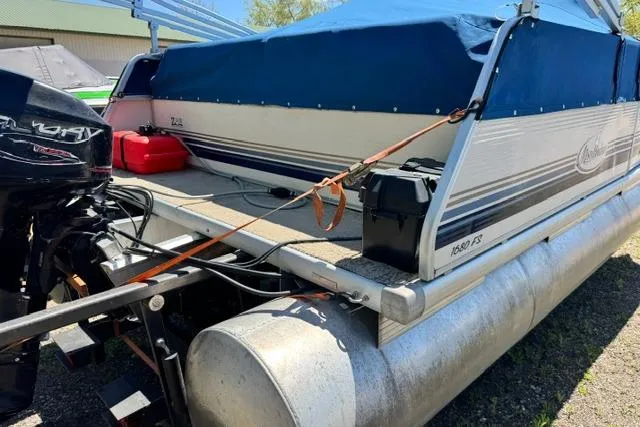 Slide: The Image of 2005 Misty Harbor 1680FS pontoon boat with blue cover and outboard motor. - 4