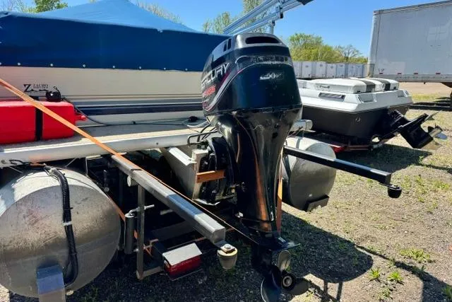 Slide: The Image of 2005 Misty Harbor 1680FS pontoon boat with Mercury outboard motor, parked outdoors. - 6