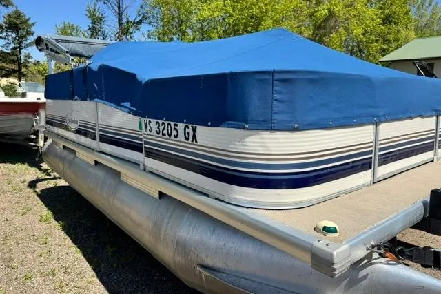 Slide: The Image of 2005 Misty Harbor 1680FS pontoon boat with blue cover, parked outdoors. - 7