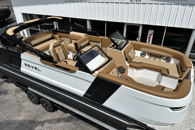 Slide: The Image of 2026 Revel RS25 boat with luxurious seating and modern design, parked outside a showroom. - 5