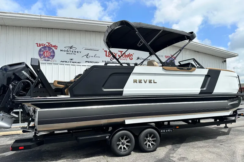 Slide: The Image of 2026 Revel RS25 boat on trailer outside dealership, featuring sleek design and Mercury engine. - 6