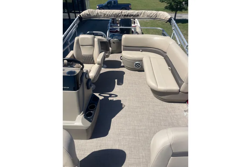 Slide: The Image of 2025 SUNTRACKER BASS BUGGY 18 interior with beige seating and steering console. - 4