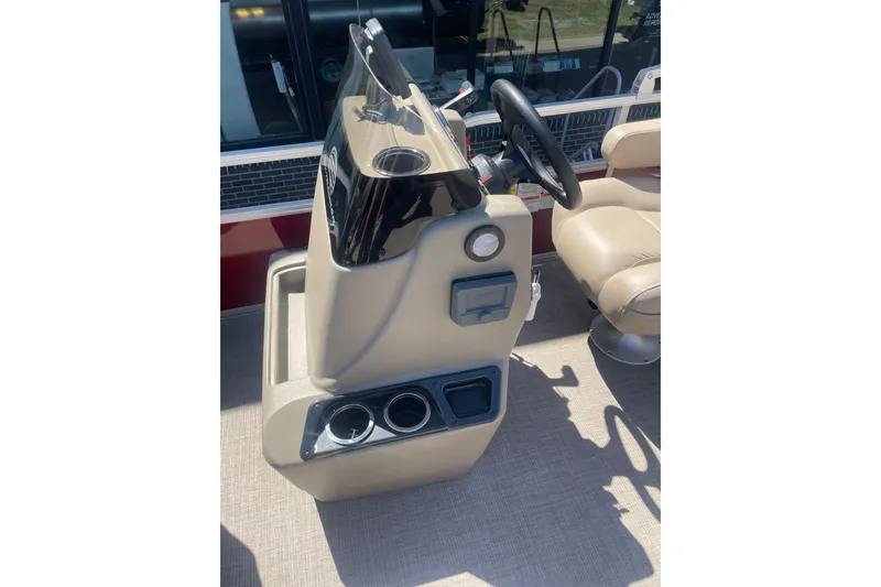 Slide: The Image of 2025 SUNTRACKER BASS BUGGY 18 boat console with steering wheel and cup holders. - 7