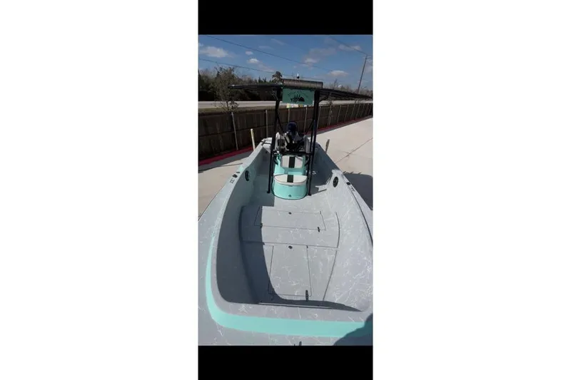 Slide: The Image of 1988 Wellcraft V-20 Sport boat with teal accents, docked under a clear blue sky. - 8