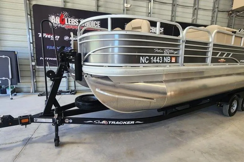Slide: The Image of 2023 Sun Tracker Fishin' Barge 20 DLX pontoon boat on trailer in garage. - 3