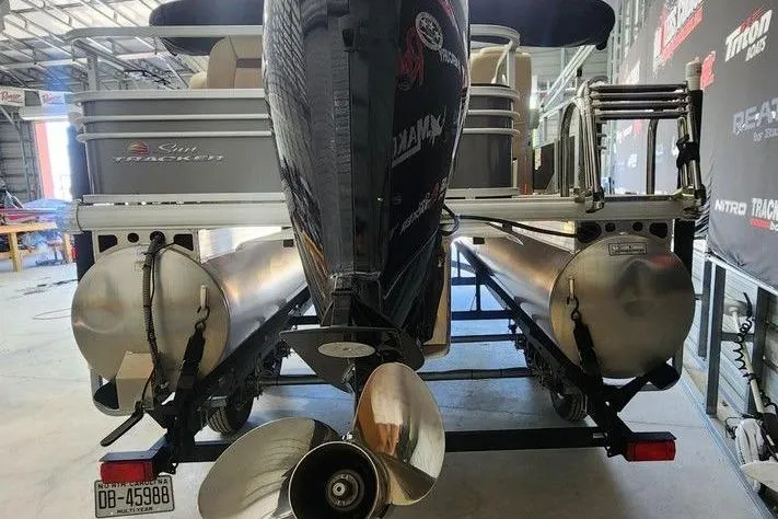 Slide: The Image of 2023 Sun Tracker Fishin' Barge 20 DLX pontoon boat in a garage setting. - 4