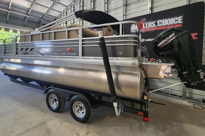 Slide: The Image of 2023 Sun Tracker Fishin' Barge 20 DLX pontoon boat with Mercury engine in a garage. - 5