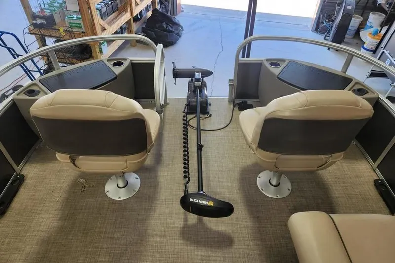 Slide: The Image of 2023 Sun Tracker Fishin' Barge 20 DLX interior with two swivel seats and trolling motor. - 7