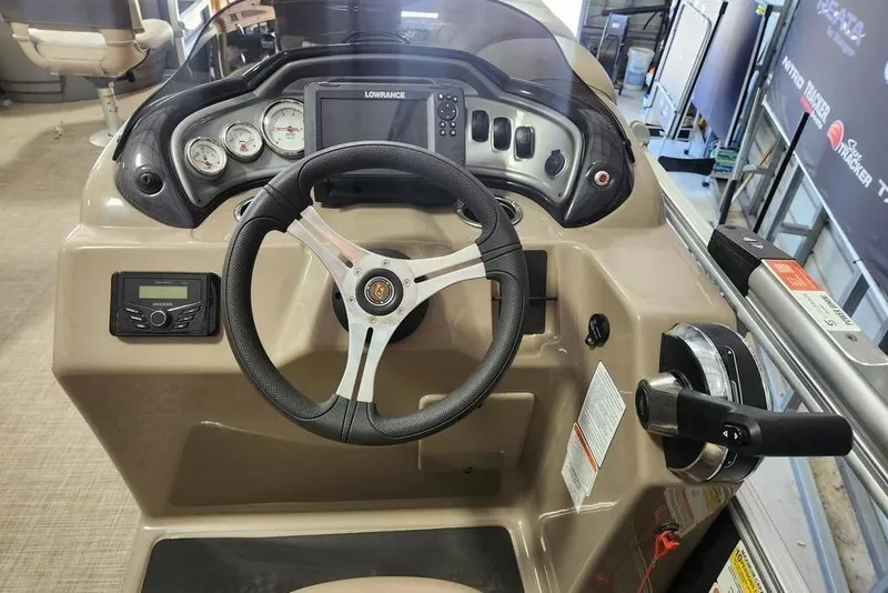 Slide: The Image of 2023 Sun Tracker Fishin' Barge 20 DLX helm with steering wheel and control panel. - 8