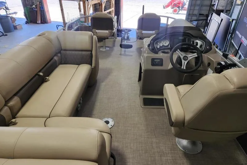 Slide: The Image of 2023 Sun Tracker Fishin' Barge 20 DLX interior with beige seating and steering console. - 9