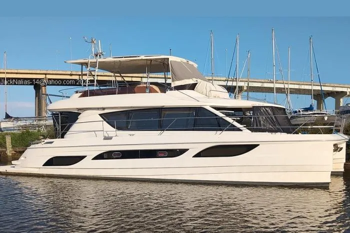 The Image of Aquila 48 yacht from 2014 docked near a bridge on a sunny day. - 0