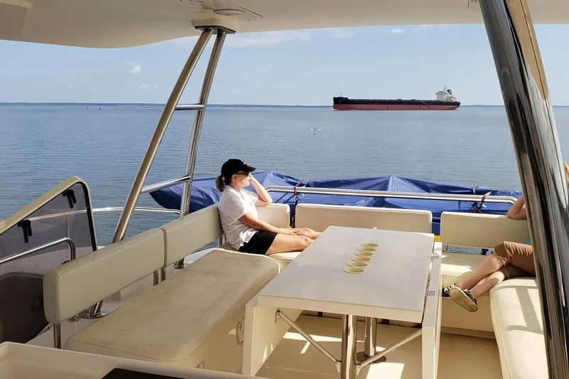 Slide: The Image of Person relaxing on 2014 Aquila 48 yacht, overlooking calm sea with distant cargo ship. - 14