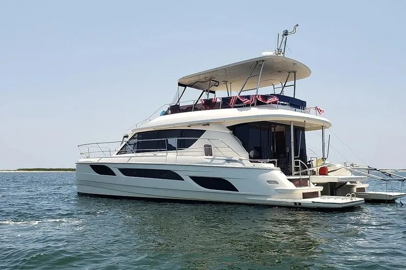 Slide: The Image of Luxury 2014 Aquila 48 yacht on calm waters, featuring sleek design and spacious deck. - 3