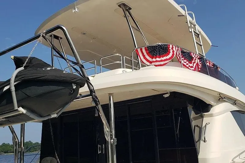 Slide: The Image of Aquila 48 yacht, 2014 model, with American flag decorations and a small boat on deck. - 4