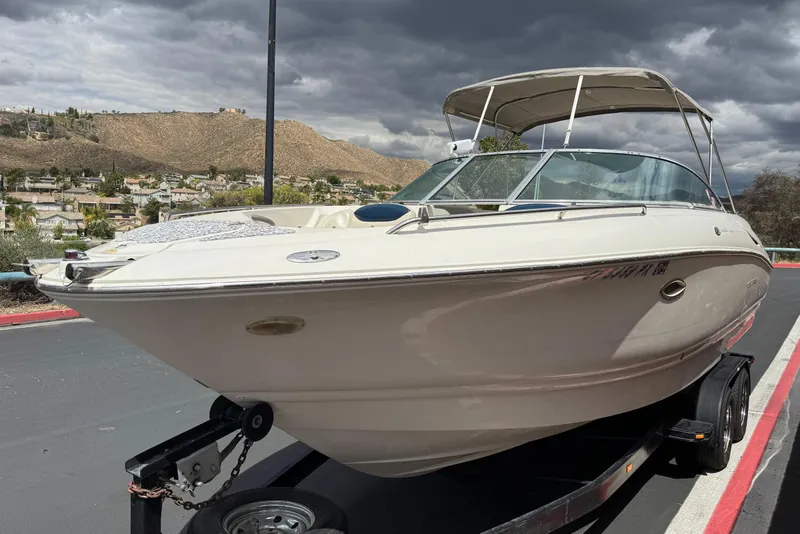Slide: The Image of 2002 Monterey 248LS Montura Bowrider on trailer, parked with scenic mountain backdrop. - 3