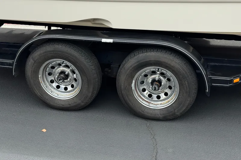 Slide: The Image of Trailer wheels of a 2002 Monterey 248LS Montura Bowrider on asphalt. - 30