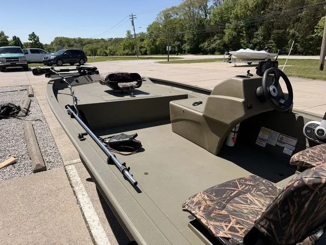 Slide: The Image of 2018 Tracker Grizzly 1754 SC boat in parking lot, green color, camo seats. - 11