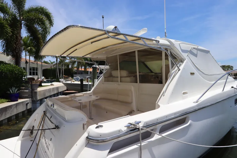 Slide: The Image of 2008 Tiara Yachts 4300 Sovran docked, featuring spacious seating and canopy under clear skies. - 16