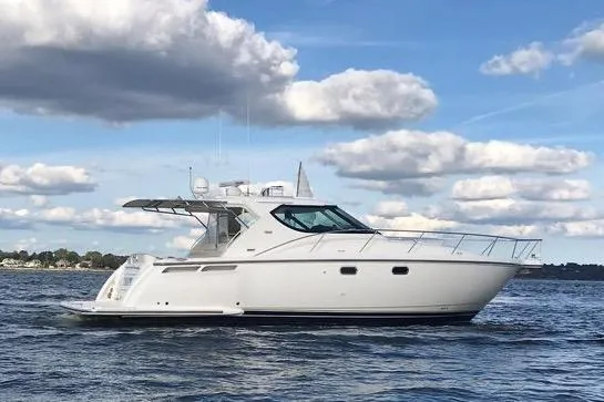 Slide: The Image of 2008 Tiara Yachts 4300 Sovran cruising on a calm sea under a partly cloudy sky. - 2