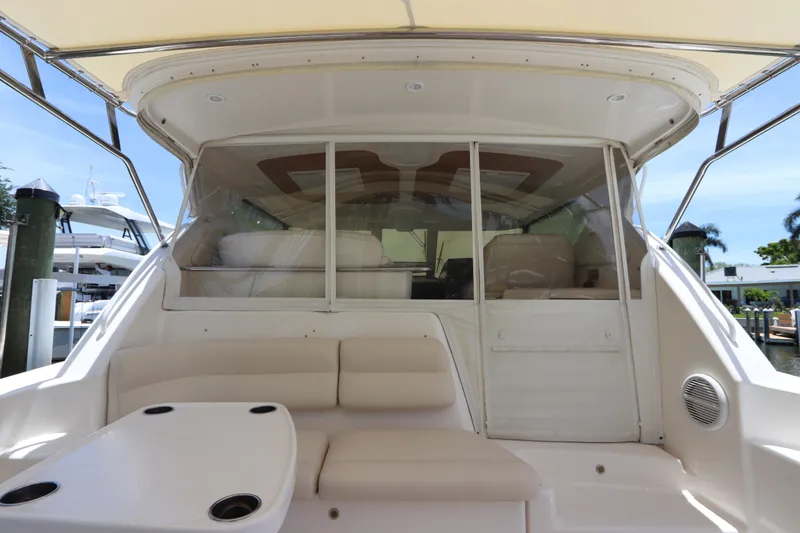 Slide: The Image of 2008 Tiara Yachts 4300 Sovran cockpit with beige seating and table, docked at marina. - 20