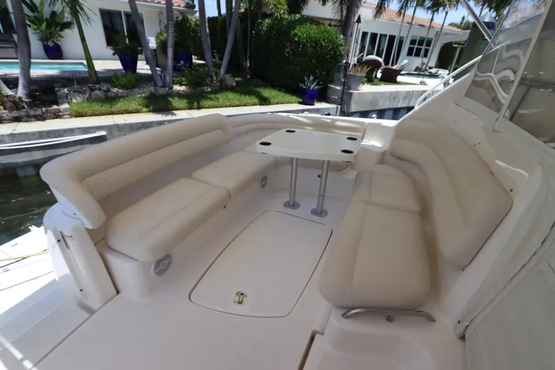 Slide: The Image of 2008 Tiara Yachts 4300 Sovran cockpit with plush seating and table, dockside view. - 21
