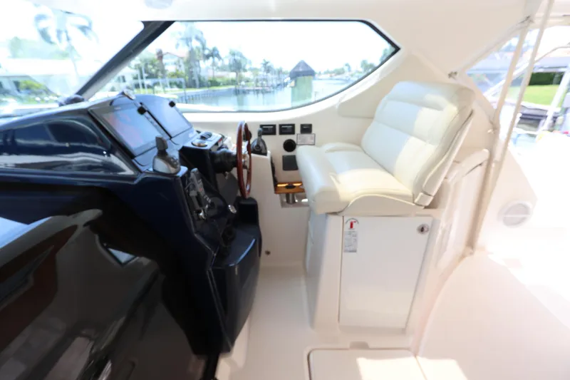 Slide: The Image of Helm of 2008 Tiara Yachts 4300 Sovran with white seating and control panel. - 29
