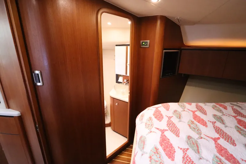 Slide: The Image of 2008 Tiara Yachts 4300 Sovran cabin interior with wooden finish and cozy bedding. - 46