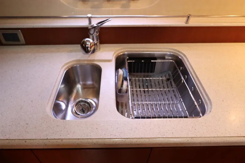 Slide: The Image of Luxury yacht kitchen sink on 2008 Tiara Yachts 4300 Sovran, featuring dual basins and modern faucet. - 57