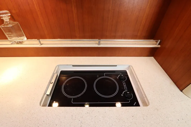 Slide: The Image of Modern kitchen cooktop on 2008 Tiara Yachts 4300 Sovran, featuring sleek design and wood paneling. - 58