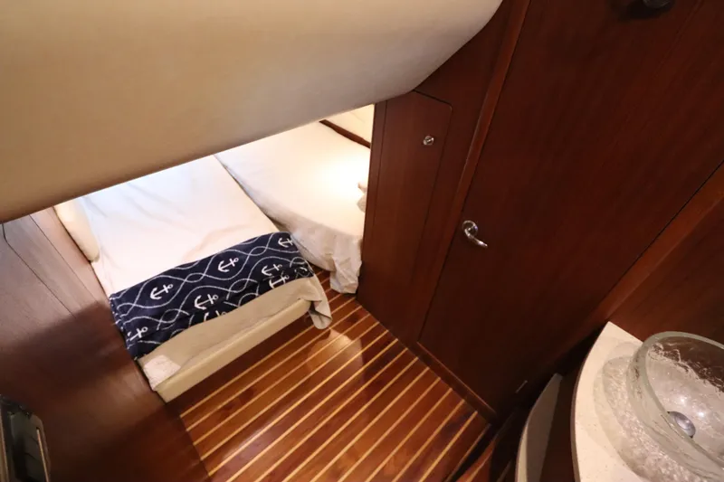 Slide: The Image of 2008 Tiara Yachts 4300 Sovran cabin interior with wooden flooring and nautical-themed bedding. - 61