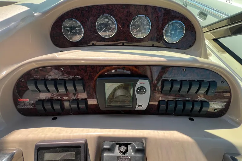 Slide: The Image of Dashboard of a 2003 Sea Ray 360 Sundancer boat with gauges and controls. - 16