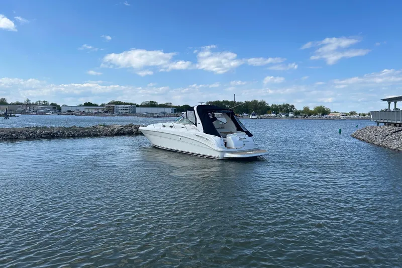 Slide: The Image of 2003 Sea Ray 360 Sundancer yacht on calm waters under a clear blue sky. - 4