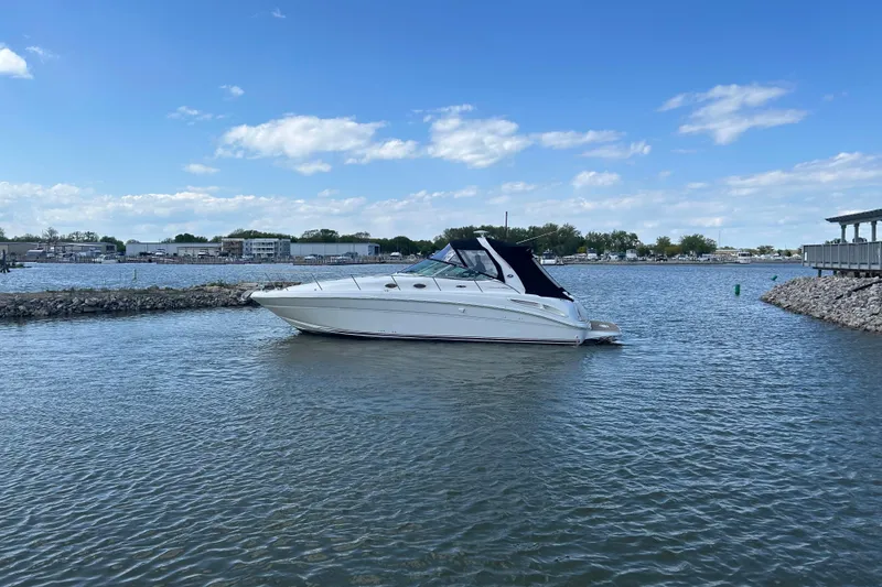 Slide: The Image of 2003 Sea Ray 360 Sundancer yacht on calm waters under a clear blue sky. - 5