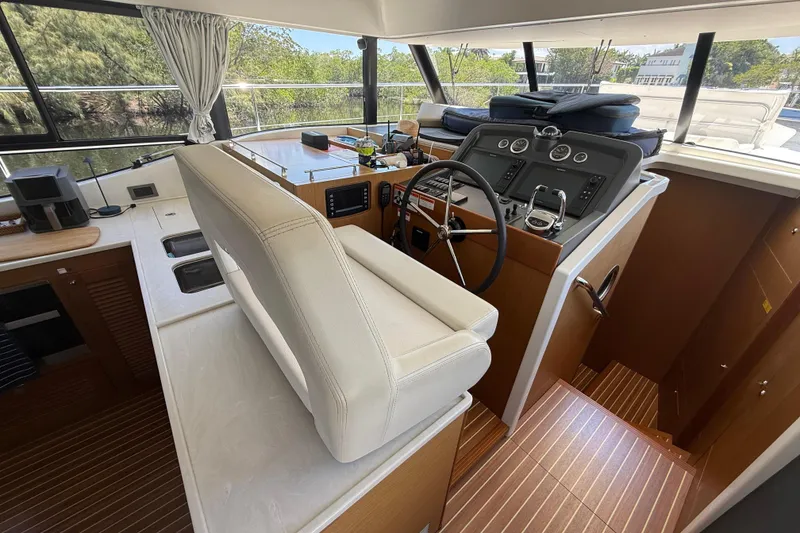 Slide: The Image of Interior helm of 2019 Beneteau Swift Trawler 47 with modern controls and seating. - 13