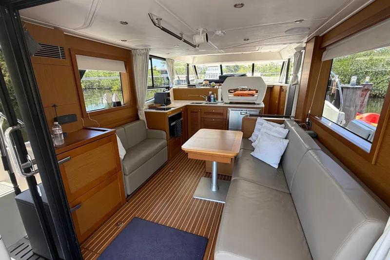 Slide: The Image of Interior of 2019 Beneteau Swift Trawler 47, featuring modern seating and wooden finishes. - 15