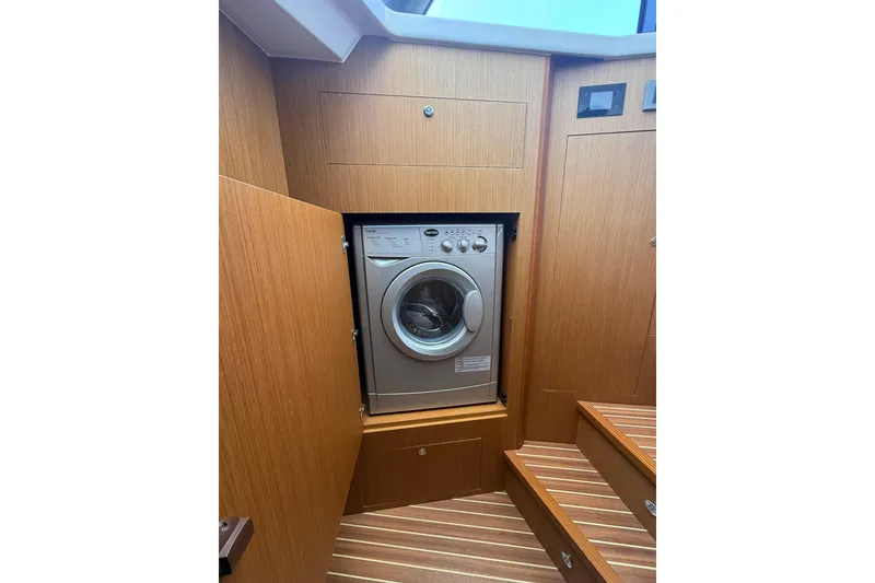 Slide: The Image of 2019 Beneteau Swift Trawler 47 interior with built-in washing machine. - 16