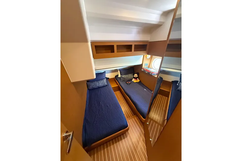 Slide: The Image of Cozy twin cabin in 2019 Beneteau Swift Trawler 47 with blue bedding and wooden accents. - 19