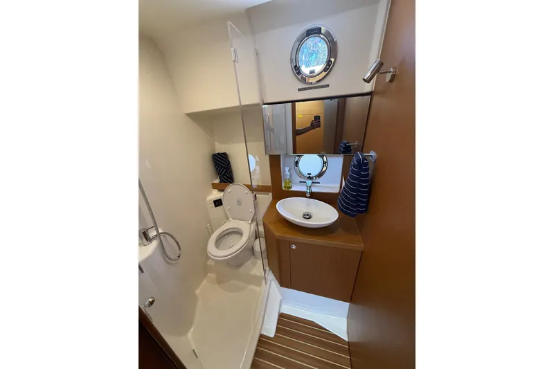 Slide: The Image of Bathroom interior of 2019 Beneteau Swift Trawler 47 with modern fixtures and porthole window. - 20