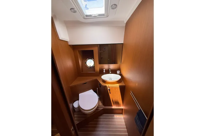 Slide: The Image of 2019 Beneteau Swift Trawler 47 bathroom with wood finish, skylight, and modern fixtures. - 21
