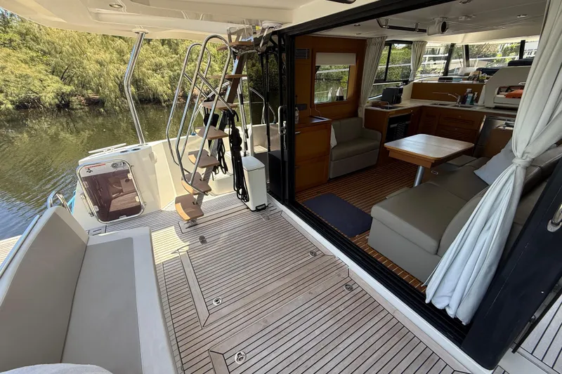 Slide: The Image of 2019 Beneteau Swift Trawler 47 interior with open deck, seating, and dining area. - 5