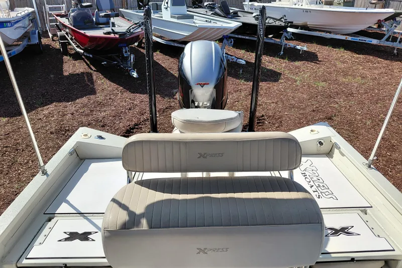 Slide: The Image of 2016 Express 20 BAY boat with Yamaha 115 engine, parked among other boats. - 23
