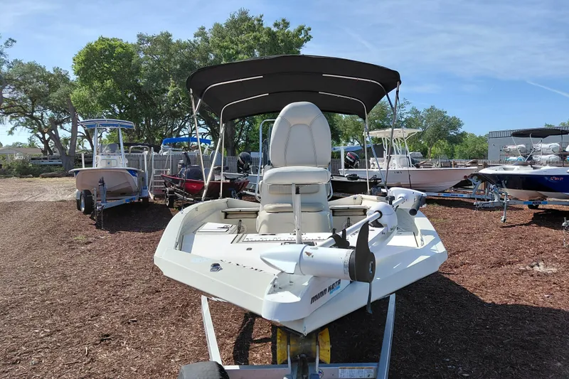 Slide: The Image of 2016 Express 20 BAY boat with canopy on trailer, surrounded by other boats. - 3