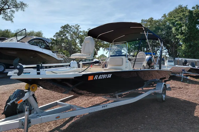 Slide: The Image of 2016 Express 20 BAY boat on trailer, parked outdoors with trees in background. - 4