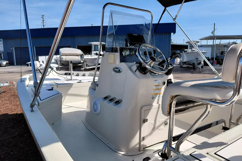 Slide: The Image of 2016 Express 20 BAY boat interior with steering console and seating in a marina setting. - 40