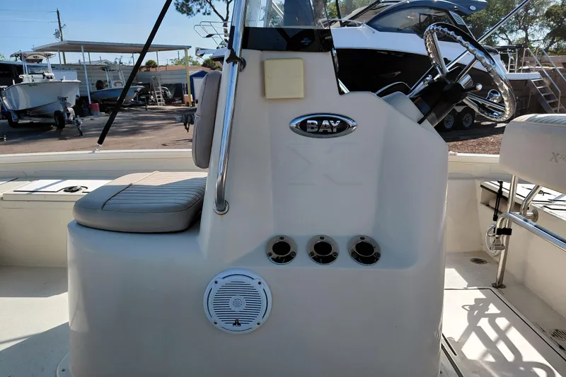 Slide: The Image of 2016 Express 20 BAY boat interior with steering wheel and seating in a marina setting. - 42
