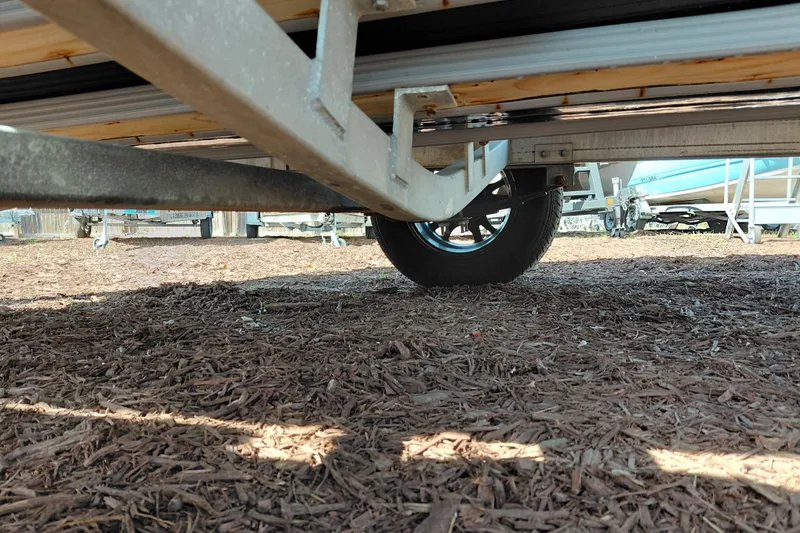 Slide: The Image of Underneath view of a 2016 Express 20 BAY trailer on mulch ground. - 43