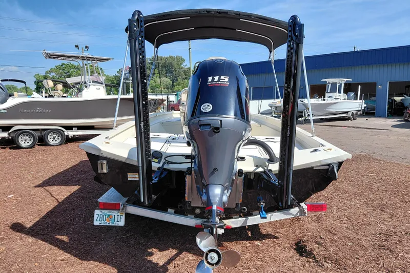 Slide: The Image of 2016 Express 20 BAY boat with 115 horsepower engine, parked outdoors near other boats. - 7