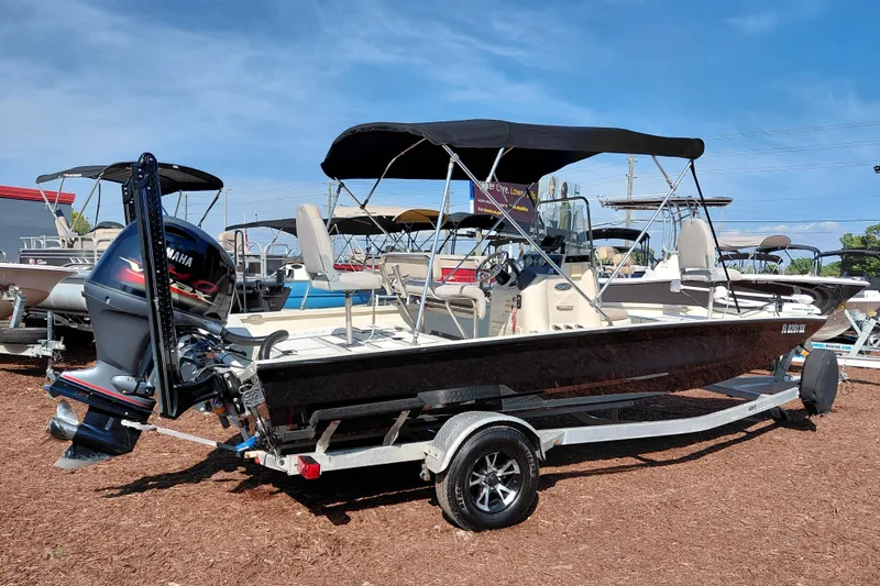 Slide: The Image of 2016 Express 20 BAY boat with Yamaha outboard motor on trailer, parked outdoors. - 9